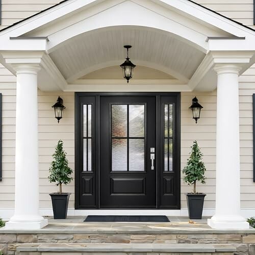 Elegant black front door with pillars and potted plants.
