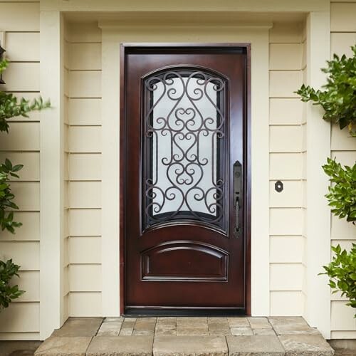 Elegant wooden front door with ornate ironwork and surrounding greenery.